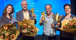 De vier vertegenwoordigers van de winnende stichtingen met hun prijs en een bos bloemen.